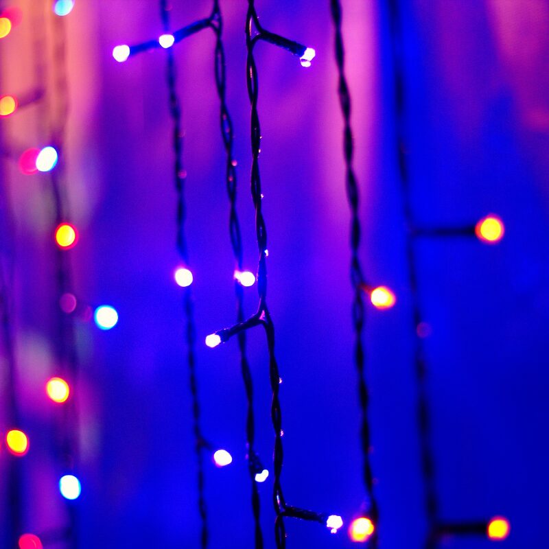 Purple Grinch-themed string lights glowing on a dark background
